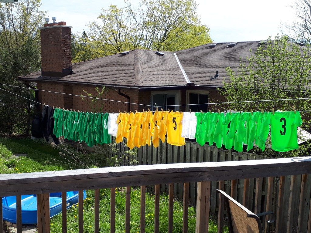 Soccer jerseys hanging on a clothesline.